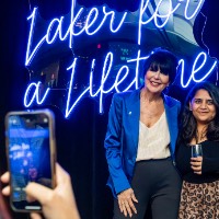 Girl stands on the right of President Mantella to take a photo with iPhone